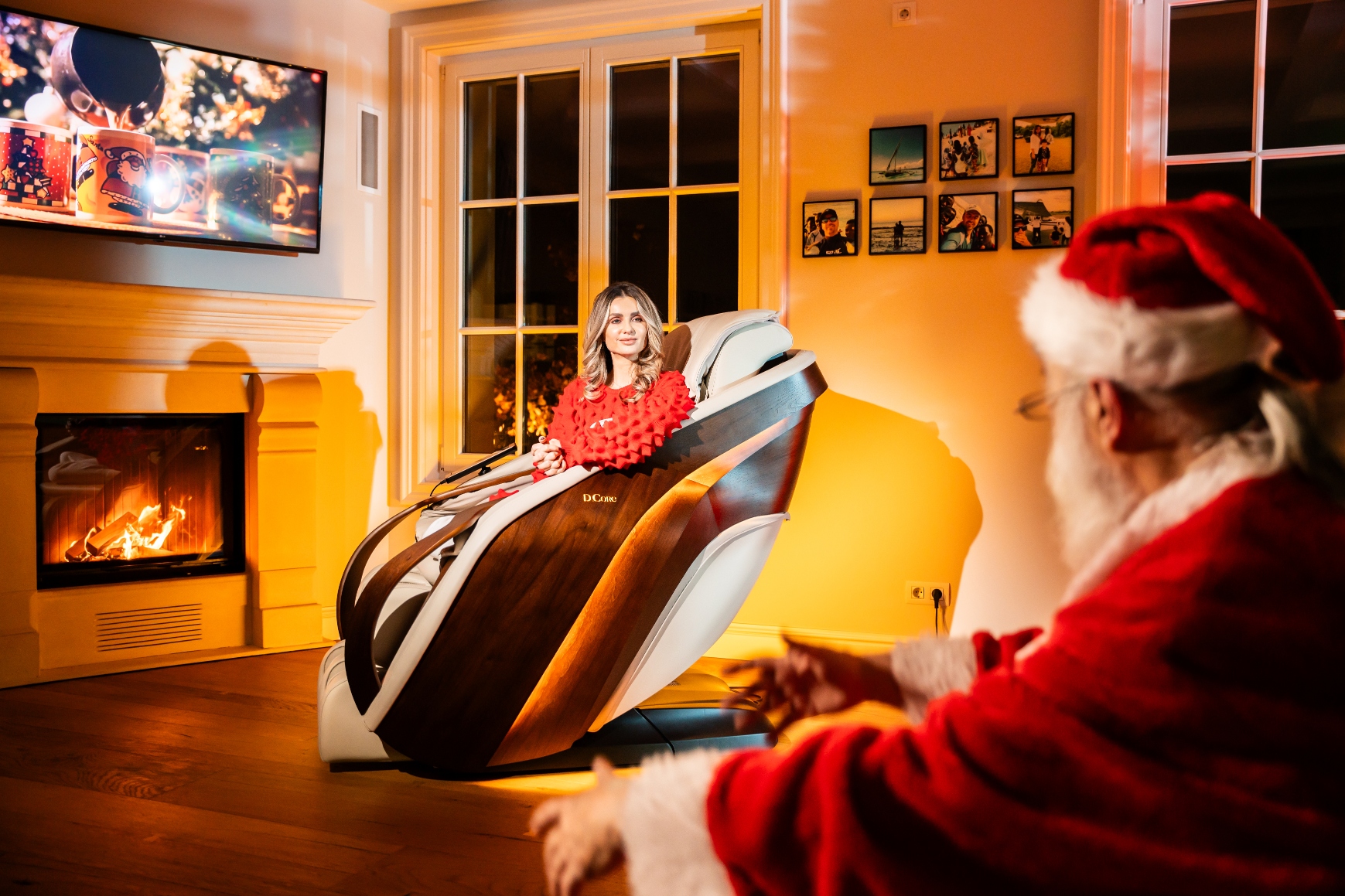 Imagine cu Moș Crăciun stând pe o canapea și o femeie stând într-un model D Core, un fotoliu de masaj japonez de la Komoder